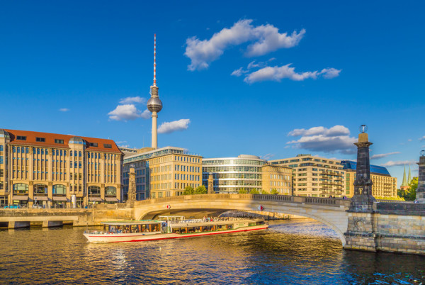 Berlin city center with ship on Spree river at sunset in summer, Germany